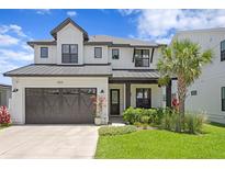 Charming two-story home features a landscaped yard, a garage, and a welcoming front porch at 303 N Beverly Ave, Tampa, FL 33609