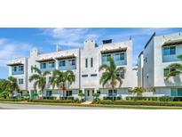 Modern townhome complex featuring a clean white facade and lush landscaping, under a clear blue sky at 3100 W Paul Ave # 15, Tampa, FL 33611