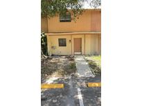 Inviting two-story townhome featuring a charming front entrance with a well-maintained walkway and landscaping at 4003 Oak Limb Ct, Tampa, FL 33614