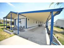 Charming single-story home featuring covered parking and a cozy front porch with seating at 5248 Antigua Dr, Zephyrhills, FL 33541