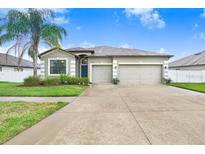 Charming single-story home featuring a well-manicured lawn and a spacious two-car garage at 6620 Paden Wheel St, Zephyrhills, FL 33541