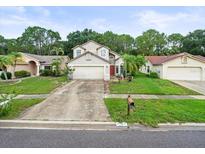 Charming two-story home with an attached two-car garage and well-maintained landscaping at 8731 Huntfield St, Tampa, FL 33635
