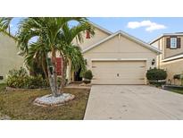 Charming home featuring a well-manicured lawn and two-car garage with a stylish design at 12017 Gillingham Harbor Ln, Gibsonton, FL 33534