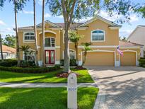 Charming two-story home featuring a red double-door entry, three-car garage, and neatly landscaped front yard at 18004 Avalon Ln, Tampa, FL 33647