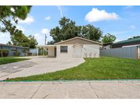 Charming single-story home with a well-maintained lawn and a covered carport at 1826 Cadillac Cir, Tampa, FL 33619