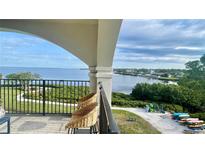Breathtaking water view from a private balcony with seating overlooking manicured lawns and shoreline at 244 & 243 Mariner Dr # 243-244, Tarpon Springs, FL 34689