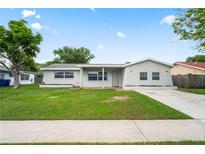 Charming single-story home features a well-maintained lawn and a classic, neutral-toned exterior at 4414 Royal Oak Ln, New Port Richey, FL 34653