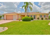 Charming single-story home featuring a lush green lawn and well-manicured landscaping at 608 Fort Duquesna Dr, Sun City Center, FL 33573