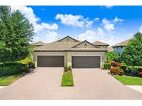 Charming villa with a two-car garage, tile roof, and manicured landscaping at 6327 Positano Ct, Sarasota, FL 34243