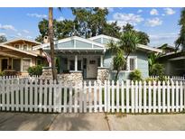 Charming light blue bungalow with a white picket fence and stone accents at 711 S Bungalow Ter, Tampa, FL 33606