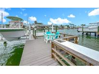 Beautiful waterfront dock with table, chairs, sink, and boat lift, perfect for enjoying the coastal lifestyle at 760 Capri Blvd, Treasure Island, FL 33706