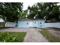 Charming, light blue single-Gathering home with a brick walkway and well-maintained front yard at 8405 N Willow Ave, Tampa, FL 33604