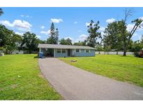 Charming single story home with a long driveway and beautiful lawn in a residential neighborhood at 903 Dixie Maid Ln, Valrico, FL 33594