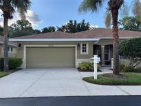 Inviting front exterior with a two-car garage and palm trees in the landscaped yard at 12749 Aston Creek Dr, Tampa, FL 33626