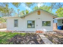 Charming single-story home with a stucco exterior, front yard, and shaded by mature trees at 1520 S Michigan Ave, Clearwater, FL 33756