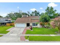 Charming single-Gathering home featuring a well-manicured lawn, two car garage, and inviting front entrance at 15711 Springmoss Ln, Tampa, FL 33624