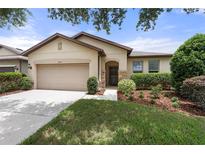 Inviting single-story home featuring a well-maintained lawn and a two car garage at 1827 Trillium Blvd, Brooksville, FL 34604