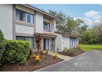 Two-story home with neutral paint, landscaping, and a private walkway leading to the entrance at 1830 Cypress Trace Dr, Safety Harbor, FL 34695