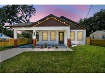 Charming home featuring a welcoming front porch, manicured lawn, and red brick accents at 1914 E Chelsea St, Tampa, FL 33610