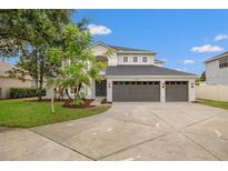 Beautiful two-story home features a three car garage, manicured lawn, and well-maintained landscaping at 21108 Bircholm Ct, Land O Lakes, FL 34637