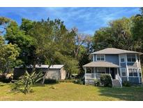 Charming two-story home with a covered porch and a lush green yard at 222 Spring Lake Hwy, Brooksville, FL 34602