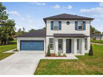 Charming two-story home with blue shutters, a well-manicured lawn and a two car garage at 301 S Daniels St, Plant City, FL 33563