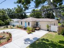 Charming single-story home with a well-maintained front yard, long driveway, and a bright blue front door at 3115 Bay Ln, Clearwater, FL 33759