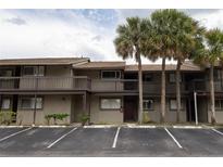 Two story condo building featuring palm trees, reserved parking and a welcoming facade at 6332 Newtown Cir # 32B2, Tampa, FL 33615