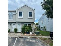 Charming townhome featuring a modern facade, well-maintained landscaping, and reserved parking at 6781 121St Ave # H, Largo, FL 33773