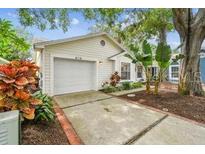 Charming single Gathering home features an attached garage and mature landscaping at 878 Franklin Cir, Palm Harbor, FL 34683