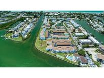 Aerial view showcasing waterfront condominiums with docks and lush landscaping at 1 Windrush Blvd # 84, Indian Rocks Beach, FL 33785