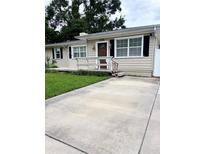 Charming single-story home featuring a well-maintained lawn, a cozy porch, and a concrete driveway at 114 N Arcturas Ave, Clearwater, FL 33765