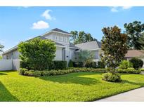 Beautifully landscaped front yard with lush lawn, manicured shrubs and a freshly painted home at 15415 Otto Rd, Tampa, FL 33624