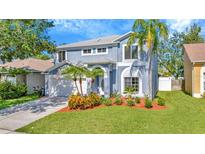 Charming two-story home with a well-manicured lawn and lovely landscaping at 1734 Mapleleaf Blvd, Oldsmar, FL 34677
