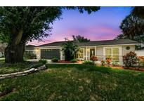 Charming single-story home featuring a well-manicured lawn and lush landscaping at 2 S Treasure Dr, Tampa, FL 33609