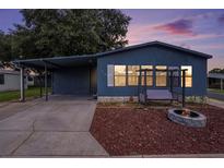Charming blue home with a cozy porch swing and fire pit in a peaceful community at 3125 Beaver Creek Dr, Wesley Chapel, FL 33543