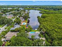 Stunning aerial view of waterfront home with pool, lush landscaping and canal access at 3225 Rosery Ne Rd, Largo, FL 33771