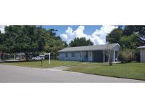 Charming single-story home with a well-maintained lawn and mature trees under a sunny, partly cloudy sky at 4105 W Tyson Ave, Tampa, FL 33611