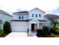 Charming two-story home with a white exterior, red door, covered porch, and well-maintained landscaping at 5546 Spanish Moss Cv, Bradenton, FL 34203