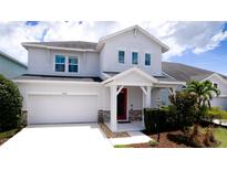 Charming two-story home features a red front door, attached garage, and well-manicured landscaping at 5546 Spanish Moss Cv, Bradenton, FL 34203