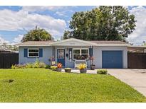 Charming blue home with a well-manicured lawn and vibrant, welcoming curb appeal, offering a warm invitation at 5690 82Nd N Ter, Pinellas Park, FL 33781