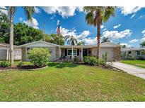 Charming single-story home featuring a well-manicured lawn, stone accents, and a welcoming front entrance at 5936 13Th Ave, New Port Richey, FL 34652