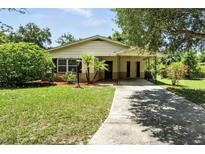 Charming single-story home with mature landscaping and a covered carport providing shade and curb appeal at 1116 W Kirby St, Tampa, FL 33604