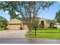Charming home with a well-manicured lawn and a beautifully paved driveway at 12439 Bristol Commons Cir, Tampa, FL 33626