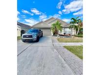 Charming single-story home featuring mature landscaping, a two-car garage, and a well-manicured lawn at 12603 Midpointe, Riverview, FL 33578