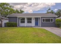 Charming single-story home with a blue front door, landscaped yard, and a well-maintained lawn at 1882 Maryland Ne Ave, St Petersburg, FL 33703