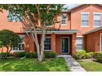 Charming two-story townhome with a well-maintained lawn, shrubs, and shade tree framing the front entrance at 2066 Sun Down Dr, Clearwater, FL 33763