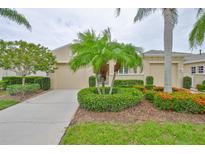 Charming single-story home featuring lush landscaping, mature trees, and a two-car garage at 2292 Sifield Greens Way # 59, Sun City Center, FL 33573