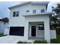 Modern two-story home with a black garage door and neutral-colored stucco exterior at 2404 Cassell St, Tampa, FL 33605