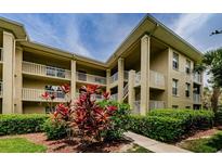 Attractive condo building featuring well-maintained landscaping and multi-level balconies at 2690 Coral Landings Blvd # 122, Palm Harbor, FL 34684